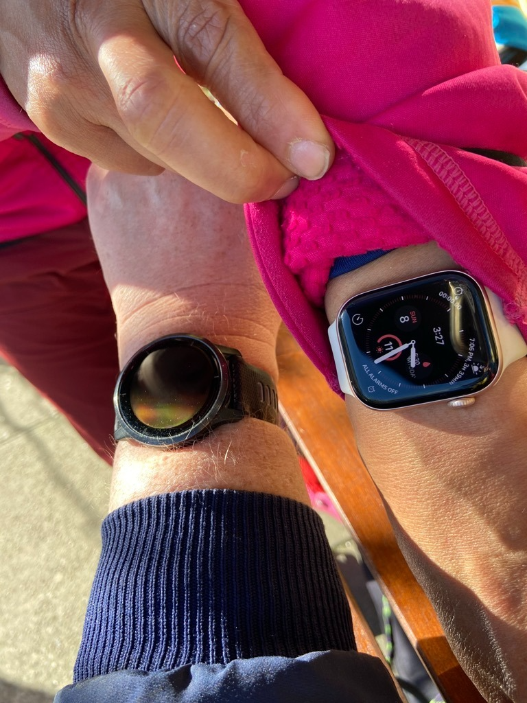 Garmin Watch next to an Apple Watch at Commercial Street Cafe, Vancouver, Canada